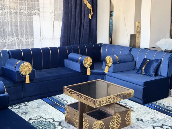 مسند كحلي بشراشيب ذهبية وطاولة نحاسية بنقش مفرّغ